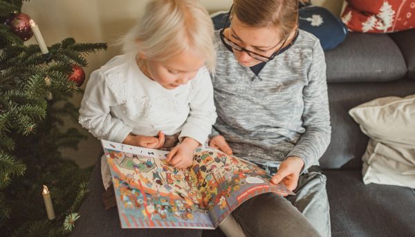 Mutter liest gemeinsam mit ihrer Tochter in einer Zeitschrift